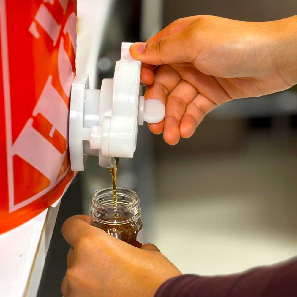 Pouring honey into a jar.
