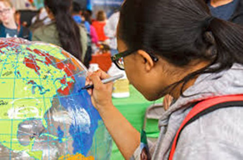 A student marks an inflatable globe.