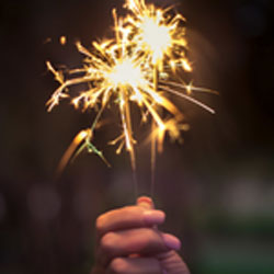 Sustainable Resolutions. A hand holding a sparkler.