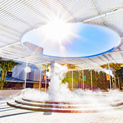 Daylight Savings and Sustainability. Sunlight pouring through the top of an arbor latice onto a fountain.
