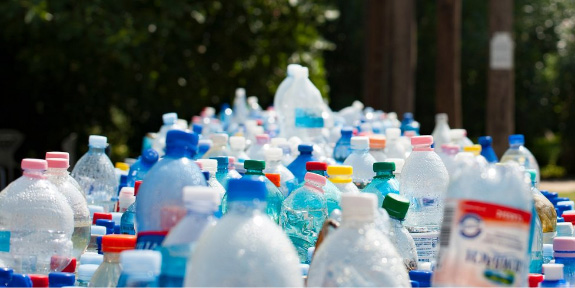 FAQ: Single-Use Plastics Phase Out. A large pile of plastic bottles.