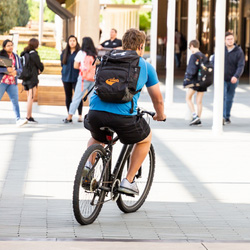 Help Future You by Registering Your Bike. A student on a bike.