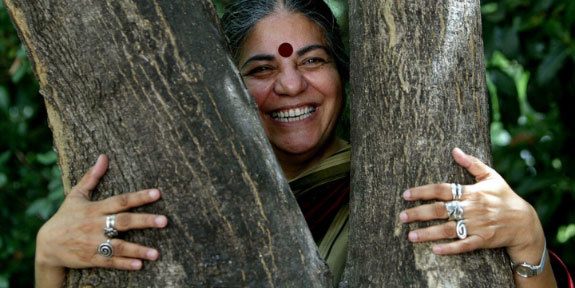 Women’s History Month. A woman smiling through the branches of a tree that she is holding.