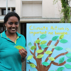 Earth Week at a Glance. A student standing next to a diagram in the shape of a tree.