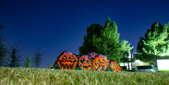 Recycle Your Halloween Candy Wrappers in October and November. Halloween pumpkin decorations on a front lawn.