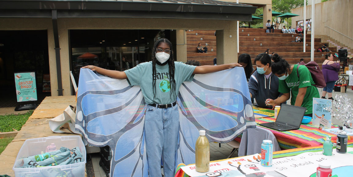 A student wearing an Earth Week t-shirt and butterfly wings.