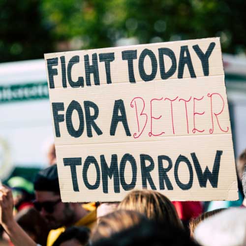 A cardboard sign held up a demostration. The sign reads “Fight Today for a Better Tomorrow”.