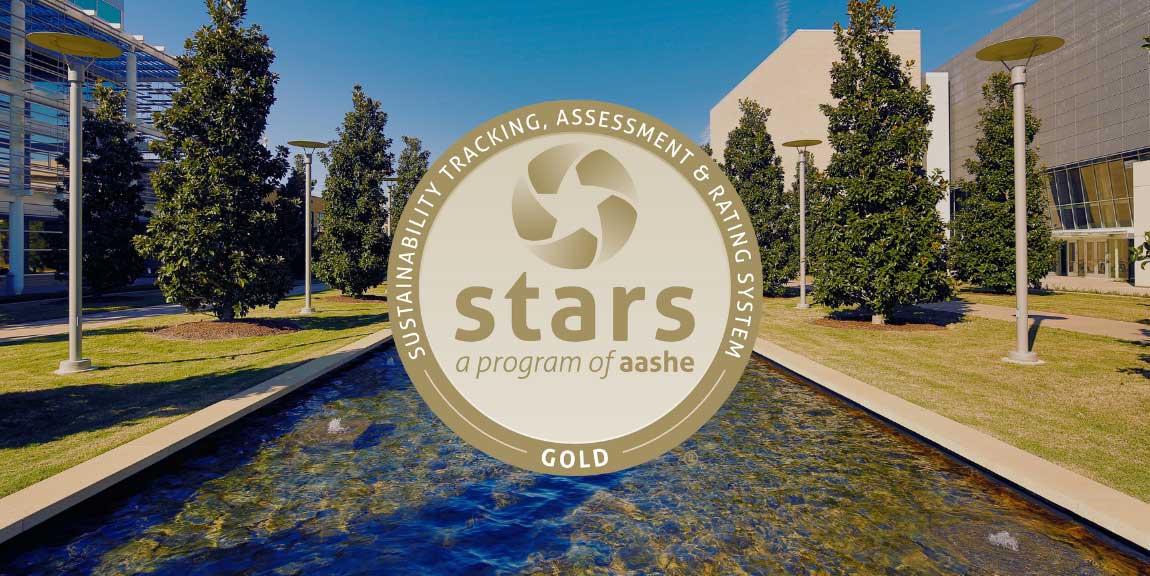 The gold AASHE STARS award floating above the south end of McDermott Mall on the UT Dallas Campus.