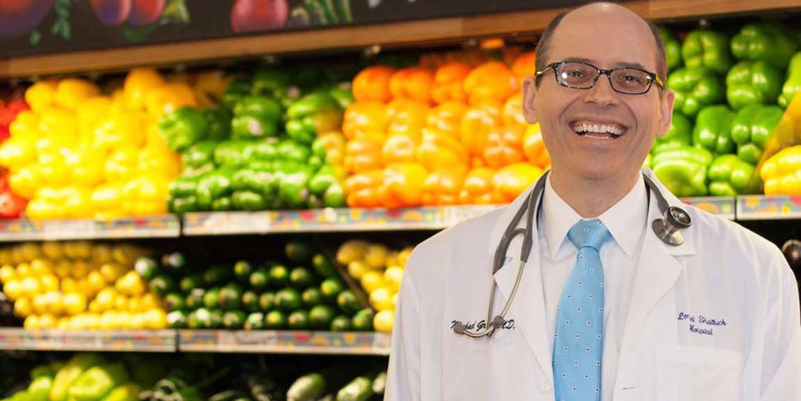 Dr. Michael Greger standing in the vegetable aisle of a grocery store.