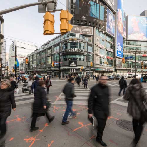 A busy urban intersection filled with people crossing the street.