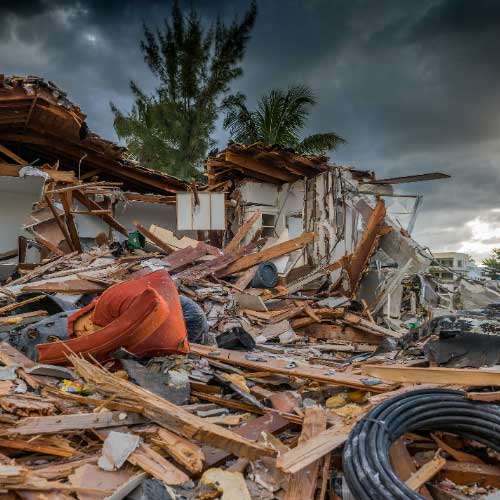 The demolished ruins of a building under stormy skies.