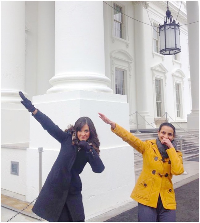 Two young women make the sign of the UTD “Whoosh” in front of a legislative building.