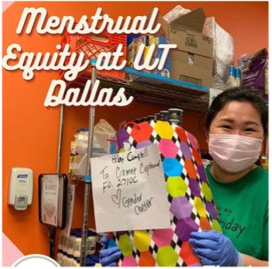 A student with donated menustrual supplies near a sign that reads “Menstrual Equity at UT Dallas”.