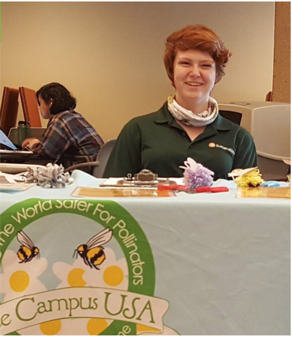 A student manning a “Bee Campus USA” table.