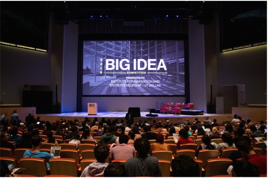 A lecture hall with a sign reading “Big Idea Competition” on the back wall.