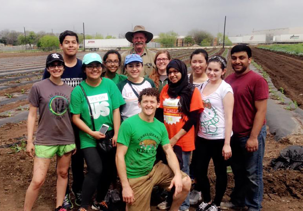 A group of students in front of a field of crops.