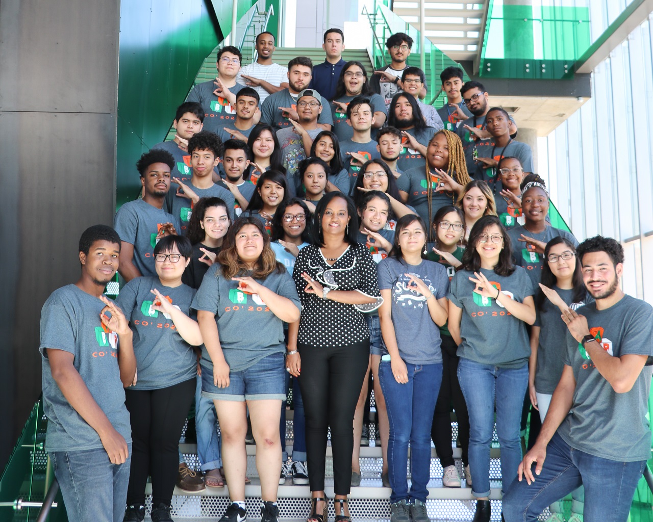 A group of students standing on the Engineering and Computer Science West stairwell, each one making the sign of the “mini whoosh”.