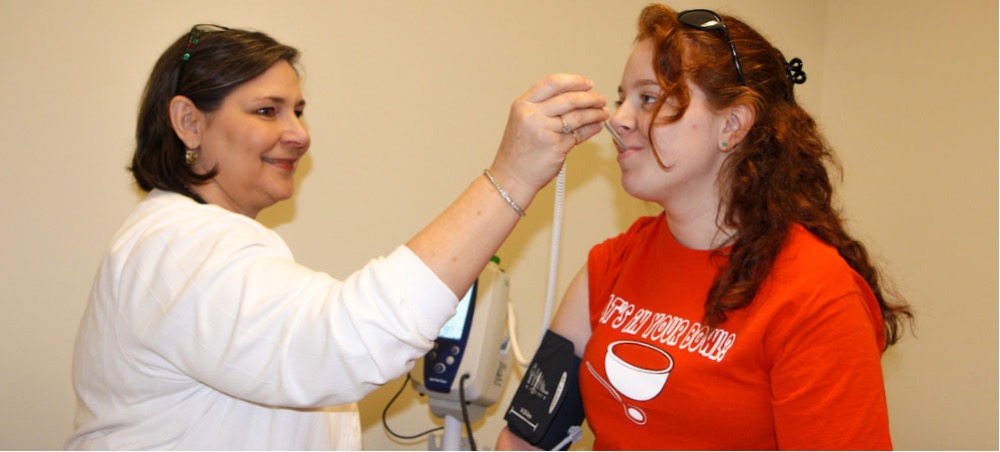 A student getting her temperature taken by a Student Health Center staff member.